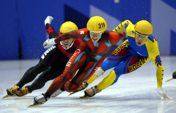 Canadian short track speed skater Mathieu Turcotte (319) is followed closely during an event in Salt Lake City at the 2002 Olympic Winter Games. (CP Photo/COA/Andre Forget).