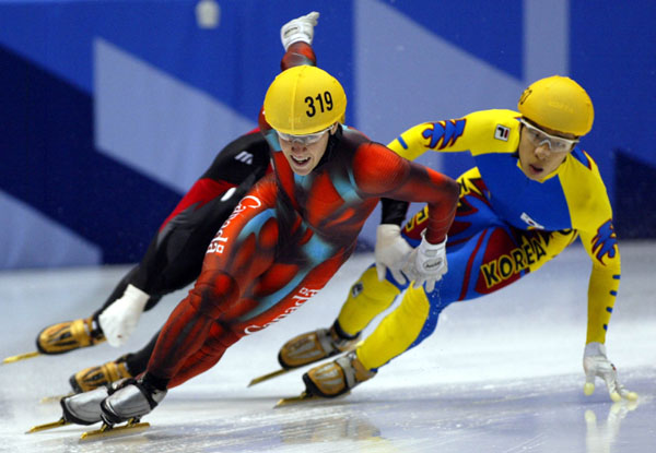 Canadian short track speed skater Mathieu Turcotte (319) is followed closely during an event in Salt Lake City at the 2002 Olympic Winter Games. (CP Photo/COA/Andre Forget).