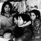 Photograph of Arnakallak's family, in their home. From left to right: Qaumajuq, Piipi Nasaq, Jonathan, Rhoda and Arnakallak, Pond Inlet (Mittimatalik/Tununiq), Nunavut, circa 1940-1944
