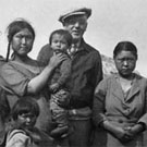 Photograph of a group of Inuit women and children and one white man, Kimmirut (formerly Lake Harbour), Nunavut, 1937