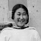 Photograph of a young Inuit woman standing in a doorway, Pangnirtung (Pangnirtuuq), Nunavut, 1929