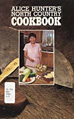 Cover of cookbook, ALICE HUNTER'S NORTH COUNTRY COOKBOOK, with an inset photograph of Alice Hunter preparing a salad. A larger photograph shows an ulu resting on an animal fur